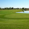 A view of green with water in background at Desert Mirage Golf Course